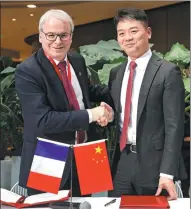  ?? AFP ?? Liu Qiangdong, CEO of JD, shakes hands with Fives Group Chairman Frederic Sanchez after signing an agreement in Beijing.