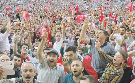  ??  ?? A CROWD CHEERS as Turkish Prime Minister Binali Yildirim speaks in Ankara after a failed coup attempt. More than 250 people were killed in the attempt, including at least 104 soldiers. The government blamed the rebellion on a theologian living in...