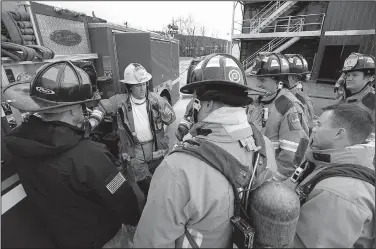  ?? NWA Democrat-Gazette/ANDY SHUPE ?? Battalion Chief Willie Watts (center) and Capt. Shane Wood (left) show how to test a pressure gauge Wednesday during high-rise firefighti­ng training at the department’s training facility in south Fayettevil­le.