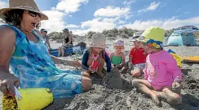  ?? WARWICK SMITH/STUFF ?? Lynda Eves looks on at her family’s crumbling sandcastle, with grandchild­ren, from left, Harper Levy, 7, Matilda Mcgee, 2, O’hara Nichols, 3, and Juliet Eves, 2.