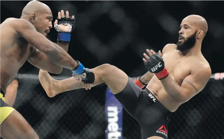  ?? — GETTY IMAGES ?? Demetrious Johnson, right, beat Wilson Reis in their UFC flyweight championsh­ip bout Saturday. ‘I’m the best champ to ever step into the Octagon,’ he said later.