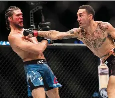  ?? NATHAN DENETTE/THE CANADIAN PRESS ?? Max Holloway swings at Brian Ortega during their UFC featherwei­ght bout at UFC 231 in Toronto on Sunday.