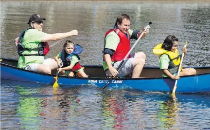  ?? PHOTOS: DARREN BROWN ?? Ottawa police Sgt. Chris Hrnchiar, left, embarks on a canoe trip with Veldon Coburn and his adopted children, Napachie and Ellie, on Dow’s Lake during the 17th Flotilla for Friendship on Wednesday.