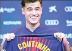  ?? AFP ?? New Barcelona midfielder Philippe Coutinho poses for pictures with a jersey before holding a press conference in Barcelona yesterday.