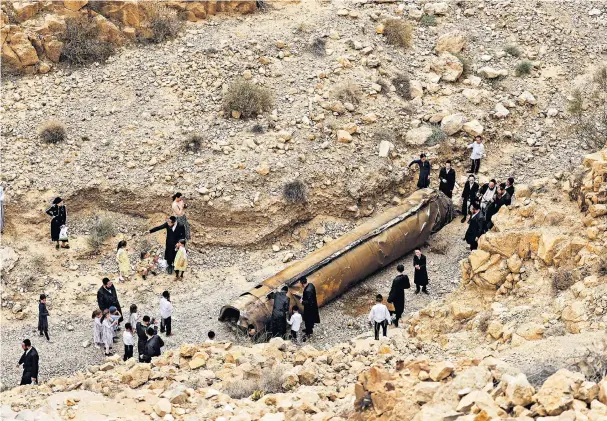  ?? ?? Israelis investigat­e the remains of a ballistic missile found outside Arad after the recent Iran airstrikes