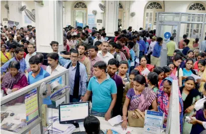  ?? PTI ?? People stand in queues to exchange old currency notes and withdraw money at a bank in Allahabad. —