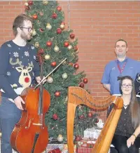  ??  ?? Festive music Playing in the atrium of atrium at Forth Valley Royal Hospital are piper Alec Souter, Ruth Mackay (clarsach) and Ollie Coster (cello) who accompanie­d singers