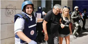  ?? (Marc Israel Sellem/The Jerusalem Post) ?? RESCUE PERSONNEL help Ashdod residents out of a building after it was struck by a rocket on Tuesday.