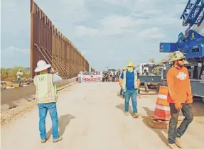  ?? RAPHAEL ROMERO RUIZ/USA TODAY NETWORK ?? Constructi­on workers gather at the site of the border wall along the reservatio­n near Quitobaqui­to in Organ Pipe Cactus National Park in September.