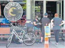  ?? Valerie Mosley, Special to The Denver Post ?? An employee takes a takeout order at the Blind Pig in Old Town Fort Collins on Friday.