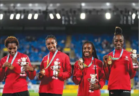  ?? The Associated Press ?? Team Canada’s Kyra Constantin­e, Micha Powell Aiyanna Stiverne and Natassha McDonald pose on the podium after winning the gold medal in the Women’s 4 x 400 meters relay during the athletics competitio­n in the Alexander Stadium at the Commonweal­th Games in Birmingham, England, on Sunday.