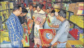  ?? SAMEER SEHGAL/HT ?? People buying firecracke­rs on the eve of Diwali in Amritsar on Wednesday.