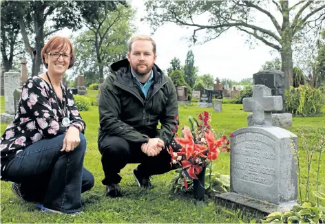  ?? ALLAN BENNER/STANDARD STAFF ?? Kathleen Powell, left, and Adrian Petry from the St. Catharines Museum and Welland Canals Centre kneel beside the tombstone of Antonio Collini, who fell to his death on July 26, 1927. The 15-year-old was the youngest canal worker to lose his life...