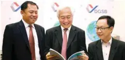  ??  ?? From left: Lau, chairman Datuk Mah Siew Kwok and Voon browsing through the annual report after the group's AGM in Kuala Lumpur yesterday.