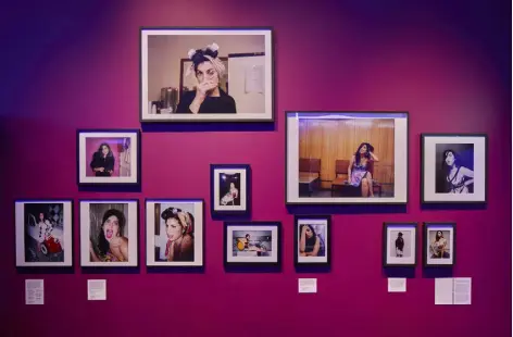  ?? Ed Reeve via © The New York Times Co. ?? A wall of photograph­s in the exhibition “Amy: Beyond the Stage,” at the Design Museum in London, depict the evolution of Winehouse’s style around the release of her first album, “Frank,” in 2003.