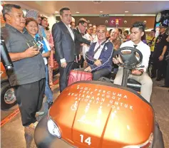  ??  ?? Loke (fifth left) and MAHB acting group chief executive officer Raja Azmi Raja Nazuddin (seven left) look at a buggy facility for special needs which is part of the ‘Happy Guests, Caring Hosts’ service culture and senior citizen and family-friendly facilities at the klia2.