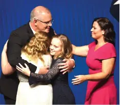  ?? — AFP photo ?? Morrison hugs his daughters Abbey (left) and Lily with wife Jenny Morrison after the Liberal Party’s campaign launch in Melbourne.