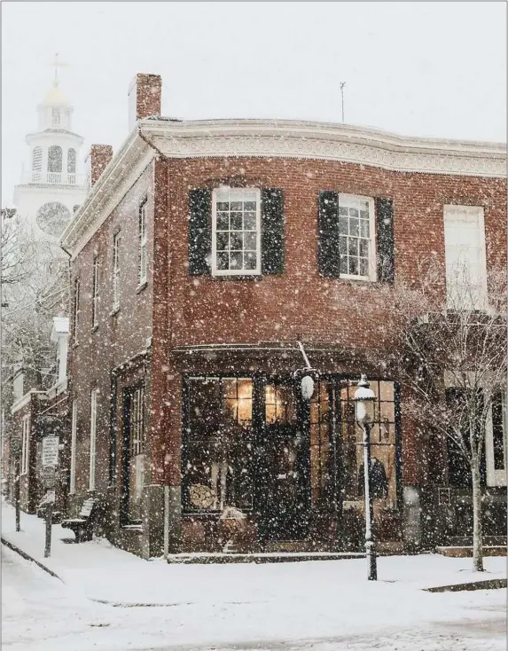  ?? PHOTO GEORGIE MORLEY, COURTESY MASSACHUSE­TTS OFFICE OF TRAVEL AND TOURISM ?? Brick façade in snow with Congregati­onal Church behind it on the corner of Main and Orange Streets in Downtown Nantucket.