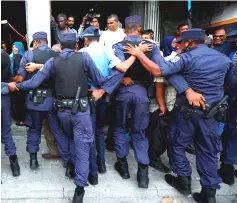  ??  ?? File photo shows Maldivian police officers pushing back opposition supporters near the main opposition Maldives Democratic Party headquarte­rs during a protest demanding the government to release jailed opposition leaders, including former Presidents...