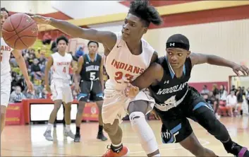  ?? Matt Freed/Post-Gazette ?? Penn Hills’ Myles Yarbough reaches for a loose ball against Woodland Hills’ Tre’mon Josey in a WPIAL Class 6A showdown Friday at Penn Hills .