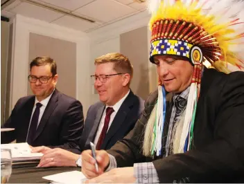  ?? MORGAN MODJESKI ?? Chief of the Saskatoon Tribal Council Mark Arcand, right, alongside Saskatchew­an Premier Scott Moe and Social Services Minister Paul Merriman was among chiefs from the STC’s member communitie­s to sign three agreements on Friday aimed at improving services for children and youth in Saskatchew­an.