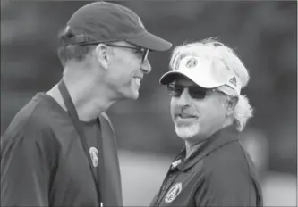  ?? ANDREW FRANCIS WALLACE, TORONTO STAR ?? Toronto Argonauts GM Jim Popp, right, talks with head coach Marc Trestman after a team practice at Alumni Stadium at York University.