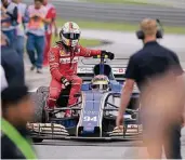  ?? FOTO: AP ?? Sebastian Vettel fährt bei Pascal Wehrlein auf dessen Sauber die Ehrenrunde zu Ende, nachdem sein Ferrari in einen Crash verwickelt war.