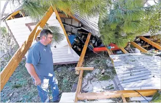  ?? GERALD HERBERT/ASSOCIATED PRESS ?? Jeff Pearsye checks Saturday on his shed that was destroyed by fallen trees in the aftermath of Hurricane Michael in Panama City, Fla.