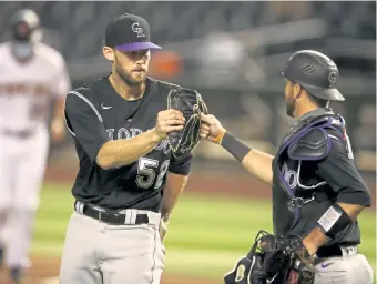  ?? Christian Petersen, Getty Images ?? Colorado relief pitcher Daniel Bard celebrates with catcher Drew Butera after defeating the Arizona Diamondbac­ks on Monday night.