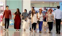  ?? — File photo ?? Shoppers walk through The Dubai Mall, which recorded a visitor footfall of 39 million in the first half of 2017.