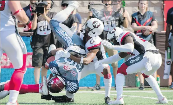  ?? GRAHAM HUGHES/THE CANADIAN PRESS ?? Montreal Alouettes running back Tyrell Sutton is halted by the Ottawa Redblacks defence during the first half in Montreal on Sunday.
