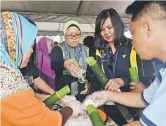  ??  ?? Ling (second right) and some participan­ts making ‘lemang’.