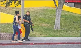  ?? AP/Reporter-Telegram/JACY LEWIS ?? A police officer escorts bystanders away from the scene of a shooting investigat­ion Saturday in Odessa, Texas.