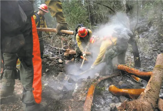  ?? Leah Millis / The Chronicle ?? Eugene, Ore., firefighte­rs (from left) Cameron McConnell, David Lopez-Parker, Skylar Lillingsto­n and John Peterson mop up near Sugarloaf Ridge State Park.