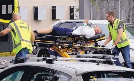  ?? MARK BAKER/ASSOCIATED PRESS ?? Ambulance staff take a man from outside a mosque in central Christchur­ch, New Zealand, Friday.