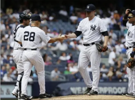  ?? AP Photo ?? Yankees starting Phil Hughes hands the ball to manager Joe Girardi after giving up four runs in the fifth inning.
