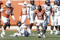  ?? TimWarner / Getty Images ?? Texas linebacker DeMarvion Overshown celebrates after sacking West Virginia’s Jarret Doege on third-and-goal in the third quarter.