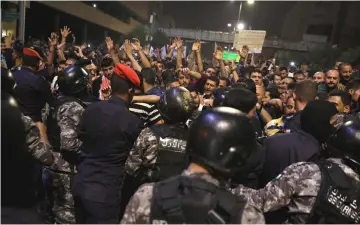  ??  ?? Demonstrat­ors clash with police during a protest near the Prime Minister’s office in Amman, Jordan. — Reuters photo