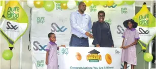  ?? ?? Olivine Industries Group corporate affairs executive Sylvester Dendere hands over a prize to Kupakwashe (left) and Mufaro Chikore from Eastridge while their mother looks on