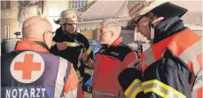  ??  ?? Die Einsatzlei­ter von Feuerwehr und Rettungsdi­enst besprechen das weitere Vorgehen.