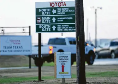  ?? Jerry Lara / Staff photograph­er ?? Signs direct contractor­s to a temperatur­e check area before entering Toyota’s San Antonio plant on Monday, when the automaker reopened plants in the U.S. and Canada that had been closed since March 23.