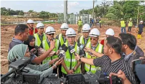  ?? — Bernama ?? Crucial fix: Fahmi (centre) facing the media after inspecting the towers at Kampung Jubakar Pantai in Tumpat, Kelantan.