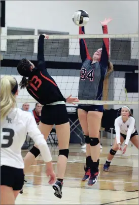  ??  ?? Heritage’s Kallie Carter provides the resistance for a kill attempt by LaFayette’s Sarah Ray during Saturday’s 6-AAAA tournament. (Photo by Scott Herpst)