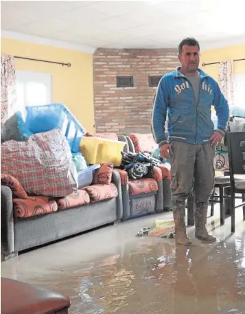  ??  ?? Un vecino de la pedanía ecijana de Isla del Vicario, en su casa llena de lodo