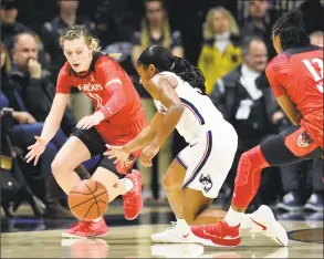  ?? Stephen Dunn / Associated Press ?? UConn’s Crystal Dangerfiel­d (5) steals the ball from Cincinnati’s Sam Rodgers (11) Wednesday night’s 82-38 win in Storrs.