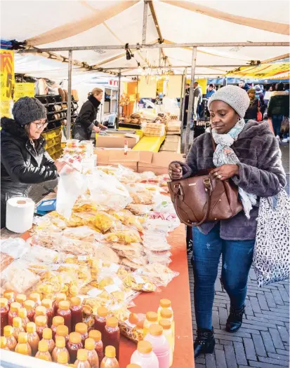  ??  ?? Winkelend publiek op de markt op het Annie Romeinplei­n in Amsterdam-Zuidoost.