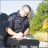  ?? Staff file photo ?? Stamford Police Officer Jeff Booth tickets drivers during a traffic stop.