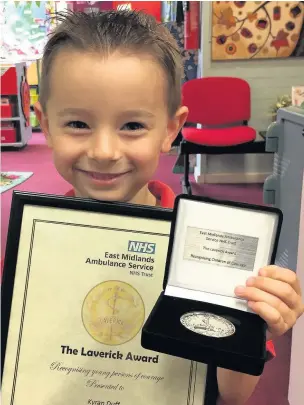  ??  ?? Kyran with his award for ringing 999 when his mother collapsed