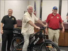  ?? KEVIN MARTIN/THE MORNING JOURNAL ?? Sheffield Lake Mayor Dennis Bring, center, sits atop a new electric patrol bicycle donated to the Sheffield Lake Police Department on Oct. 6with Chief Andrew Kory, left, and Joe Gee, left.