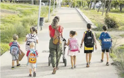  ?? Joan Cortadella­s ?? Una madre acompaña a sus hijos al colegio en Badalona, el pasado septiembre.